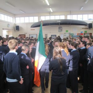 Grace Ní Mhurchú an dalta is óige sa choláiste ag iompar an Bhratach Náisiúnta.